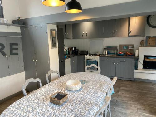 une cuisine avec une table avec un bol dessus dans l'établissement L'Heure Bleue, aux Portes