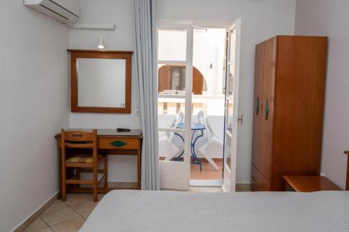 a bedroom with a bed and a desk and a table at Katerina Roza Studios - Heartfelt Hospitality in the City in Naxos Chora
