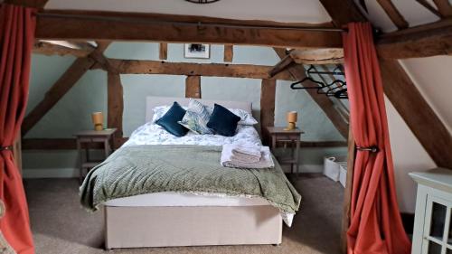 a bedroom with a bed with blue pillows at Top Floor Malthouse Studio Apartment in Much Wenlock