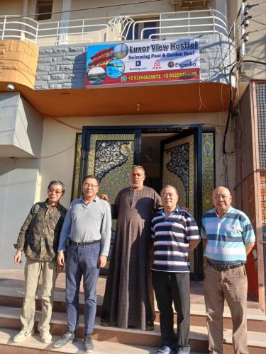a group of men standing in front of a building at Luxor View Hostel in Luxor