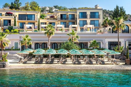 a hotel with chairs and umbrellas on the beach at Casa Nonna Bodrum - Adult Only in Bodrum City