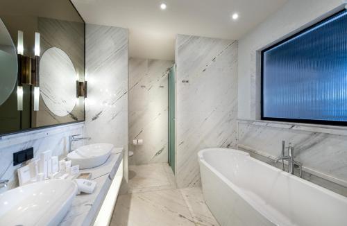 a bathroom with two sinks and a tub and a large window at Casa Nonna Bodrum - Adult Only in Bodrum City