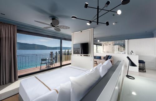 a living room with a large white couch and a large window at Casa Nonna Bodrum - Adult Only in Bodrum City