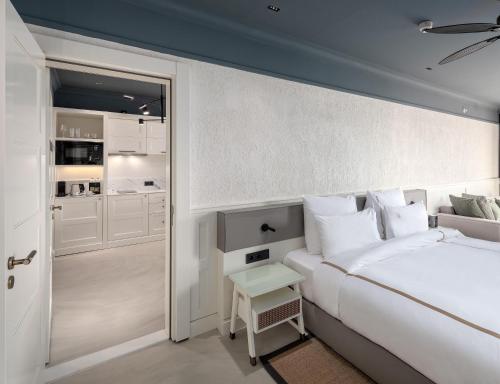 a white bedroom with a bed and a small table at Casa Nonna Bodrum - Adult Only in Bodrum City