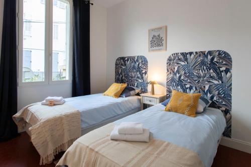 une chambre avec deux lits avec des serviettes dessus dans l'établissement C8 - Lovely House Cannes 4 BDR - Pool, AC, Garage & Wifi, à Cannes