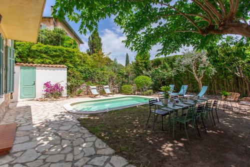 un patio avec une table et des chaises à côté d'une piscine dans l'établissement C8 - Lovely House Cannes 4 BDR - Pool, AC, Garage & Wifi, à Cannes