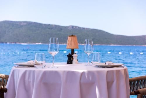 a table with wine glasses and a lamp on it at Casa Nonna Bodrum - Adult Only in Bodrum City