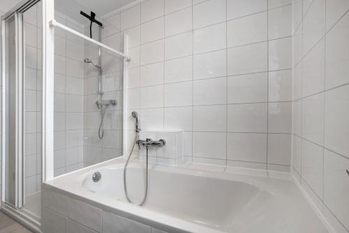 a white bathroom with a shower and a tub at Wohnung Sonnentau in Bad Wurzach