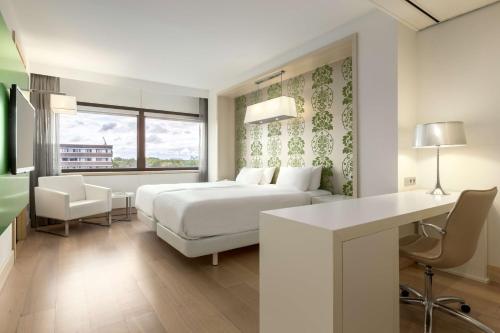 een witte slaapkamer met een bed en een bureau bij NH Amsterdam Zuid in Amsterdam