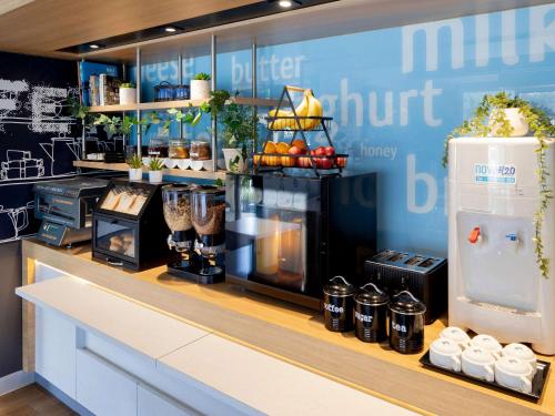 a counter in a store with a kitchen with a refrigerator at Ibis Budget - Casula Liverpool in Liverpool