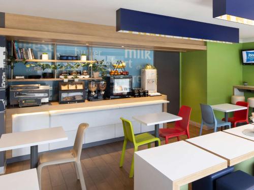 a restaurant with tables and chairs and a counter at Ibis Budget - Casula Liverpool in Liverpool
