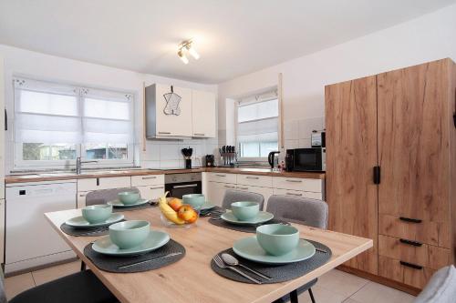 a kitchen with a wooden table with bowls of fruit on it at Wohnung Sonnentau in Bad Wurzach
