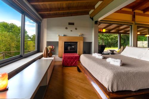 a bedroom with a large bed and large windows at Agriturismo Prato del Re in Prignano sulla Secchia