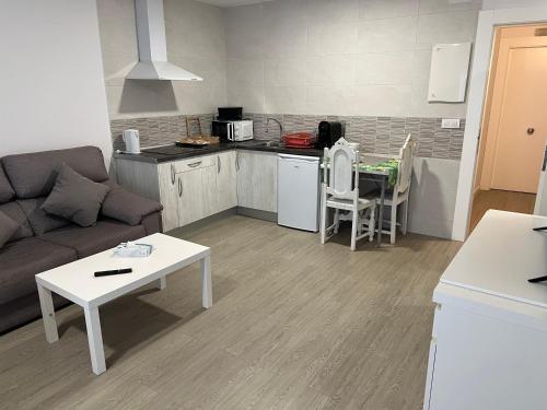 a kitchen and living room with a couch and a table at Apartamentos Sanjuan in Porriño