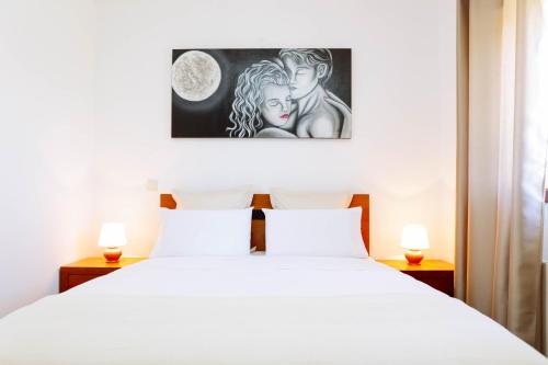 a bedroom with a white bed with two lamps at Casa Fundevila Celorico de Basto in Celorico de Basto