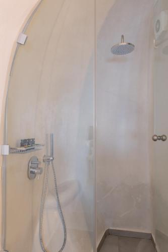 a shower with a glass door in a bathroom at Aperto Suites - Adults Only in Fira