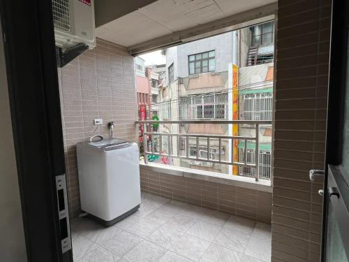 a bathroom with a window and a small refrigerator at 豐原廟東自助民宿 in Fengyuan