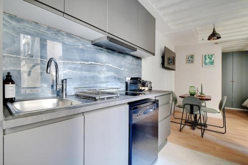 une cuisine avec un évier et un plan de travail dans l'établissement Magnifique apartment in the Marais - PARIS, à Paris
