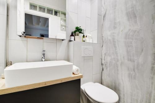 une salle de bain blanche avec des toilettes et un lavabo dans l'établissement Magnifique apartment in the Marais - PARIS, à Paris