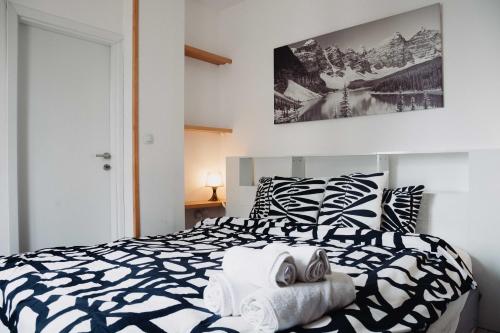 a bedroom with a black and white bed with towels on it at Seasons stay Bansko in Bansko