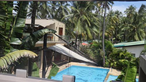 a resort with a swimming pool and palm trees at Charchoma Restaurant in Mombasa