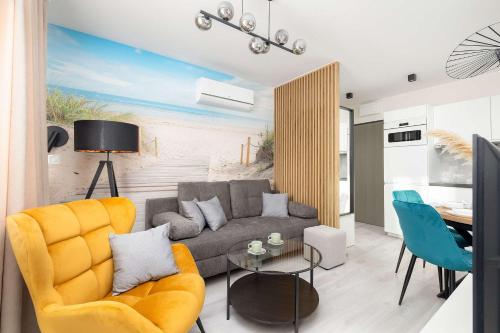un soggiorno con un divano e un tavolo di Eleganckie Apartamenty Blisko Plaży w Niechorzu z Klimatyzacją w Salonie i Parkingiem by Noclegi Renters a Niechorze