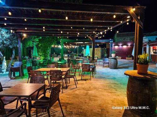 un ristorante all'aperto con tavoli, sedie e luci di Hotel Restaurante EL PATAS a Corral de Almaguer