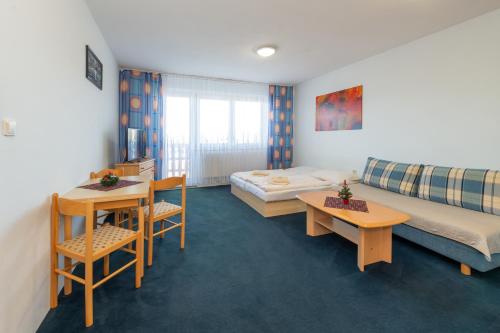 a hotel room with a bed and a table at Penzión Antares in Zuberec