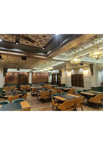 Un comedor con mesas, sillas y candelabros. en Atithyaa, en Bangalore