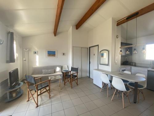 une cuisine et une salle à manger avec une table et des chaises dans l'établissement Maison cosy avec piscine partagée, au Château-dʼOléron