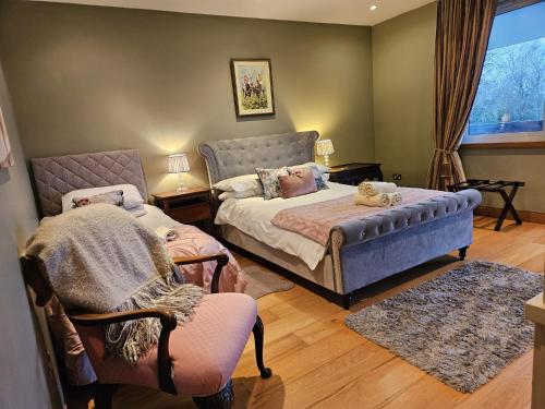 a bedroom with a bed and a chair at Hazelwood Country House in Adare