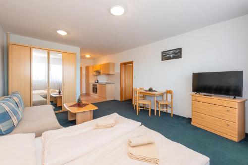 a hotel room with a couch and a television at Penzión Antares in Zuberec