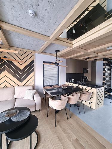 a living room with a couch and a table and chairs at Osada Maruszyna in Szaflary