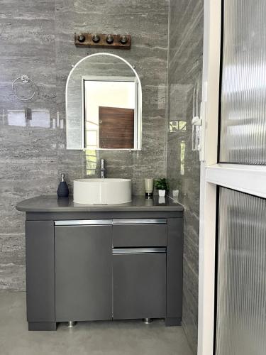 a bathroom with a sink and a mirror at Capricorn by The StayCationer in Dehradun