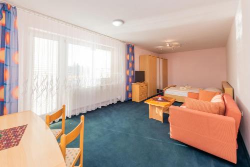 a room with a bed and a couch and a table at Penzión Antares in Zuberec