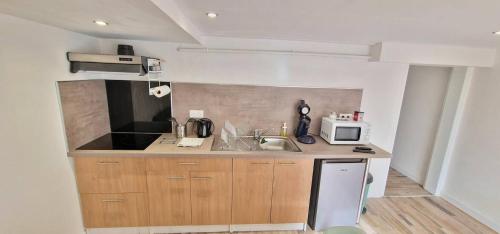 a small kitchen with a sink and a microwave at Très grande maison individuelle in Aurillac