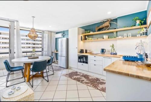 a kitchen with a table and chairs and a refrigerator at Blue Palms By The Beach in Gold Coast