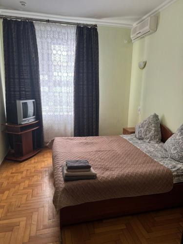 a bedroom with a bed with a tv and a window at Готель "Український Дворик" in Lviv