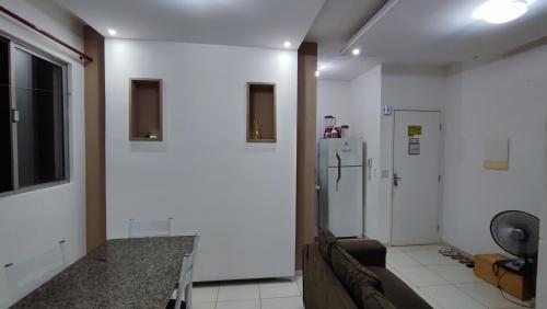 a living room with a couch and a refrigerator at Apartamento mobiliado para COP 30 próximo de Belém in Marituba