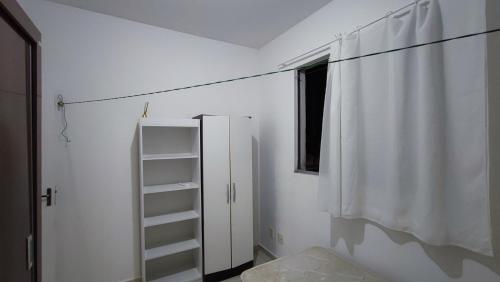 a white room with a shelf and a window at Apartamento mobiliado para COP 30 próximo de Belém in Marituba