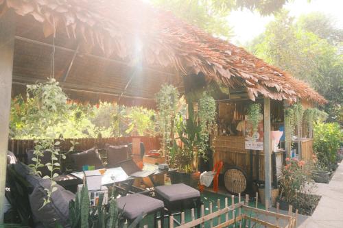 a restaurant with chairs and a table in a garden at Siem Reap Homesteading in Siem Reap
