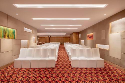 a row of white chairs in a waiting room at Country Inn & Suites by Radisson Chandigarh Zirakpur in Chandīgarh