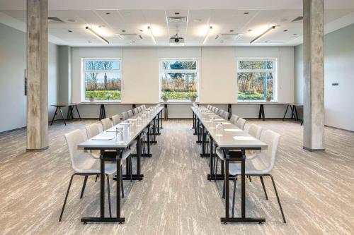 a classroom with tables and chairs in a room with windows at Park Inn by Radisson Vilnius Airport Hotel & Conference Centre in Vilnius