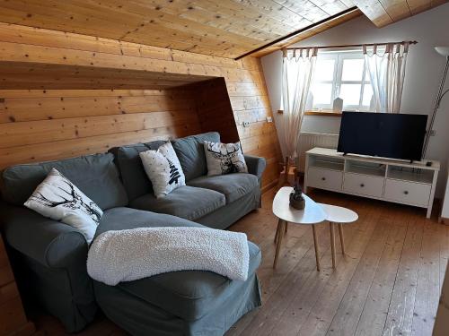 a living room with a couch and a flat screen tv at Obinghof in Fieberbrunn