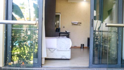 a room with a bed and a sliding glass door at Charchoma Restaurant in Mombasa