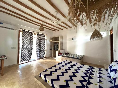 a bedroom with a bed in a room with ceilings at Mgongo tree house in Jambiani