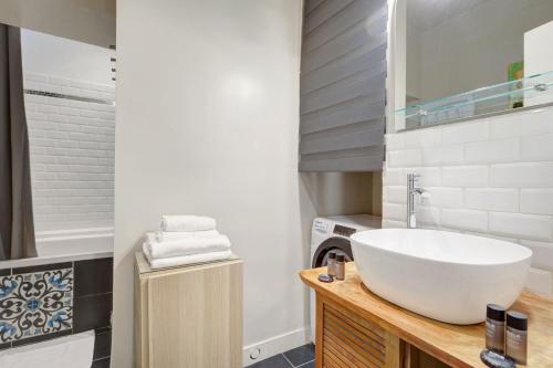 La salle de bains est pourvue d'un lavabo blanc et d'une baignoire. dans l'établissement Apartment in le marais, à Paris