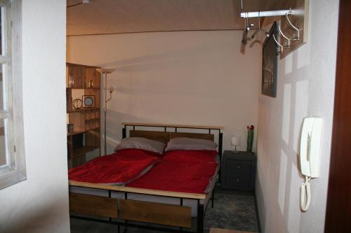 a bedroom with a bed with a red blanket at Fels- und Seenland in Ludwigswinkel