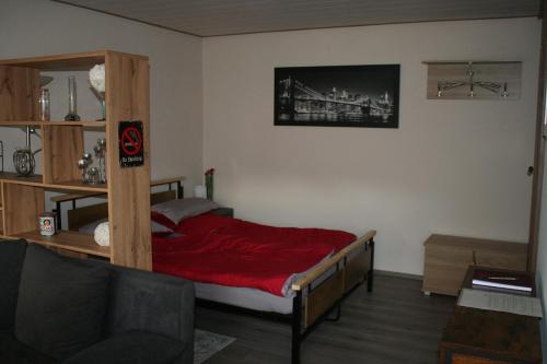 a bedroom with a bed with a red blanket at Fels- und Seenland in Ludwigswinkel