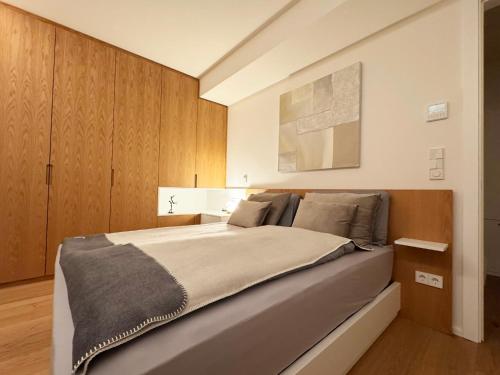 a bedroom with a large bed with wooden cabinets at Marcel Cahen 5 Luxurious Home for Families Groups and Events in Luxembourg